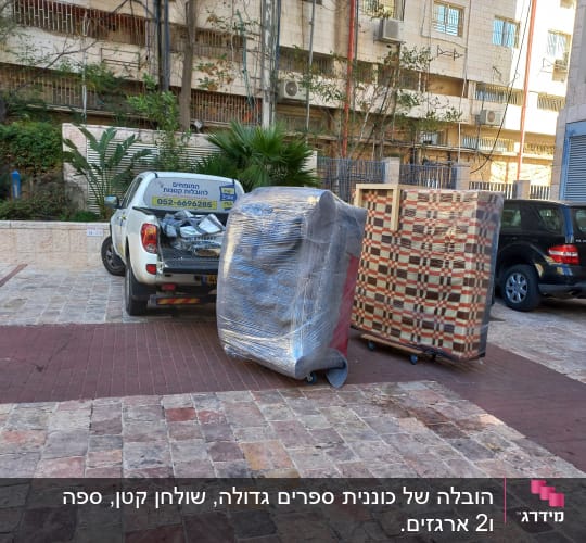 משאית הובלה עם רהיטים עטופים בניילון על גלגלים